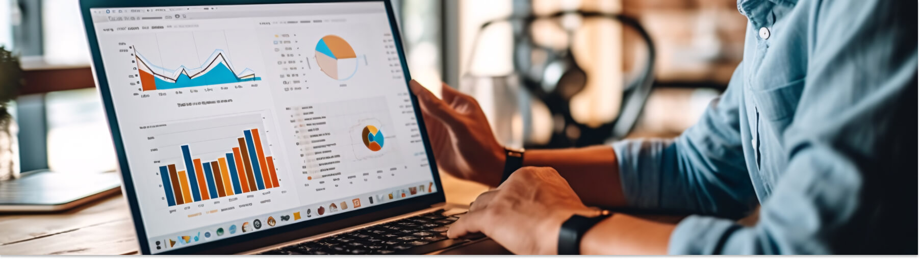Person analyzing graphs and charts on a laptop in a modern office setting.
