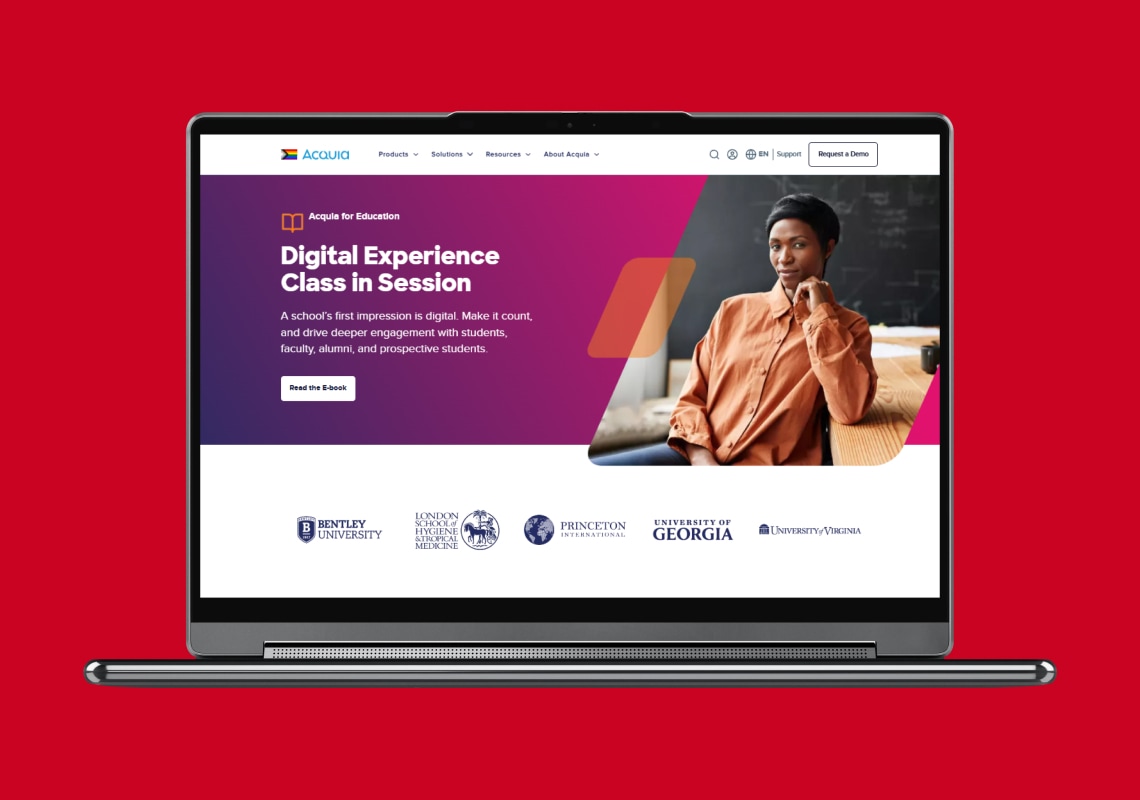 Laptop displaying Acquia's digital education experience page on a red background.