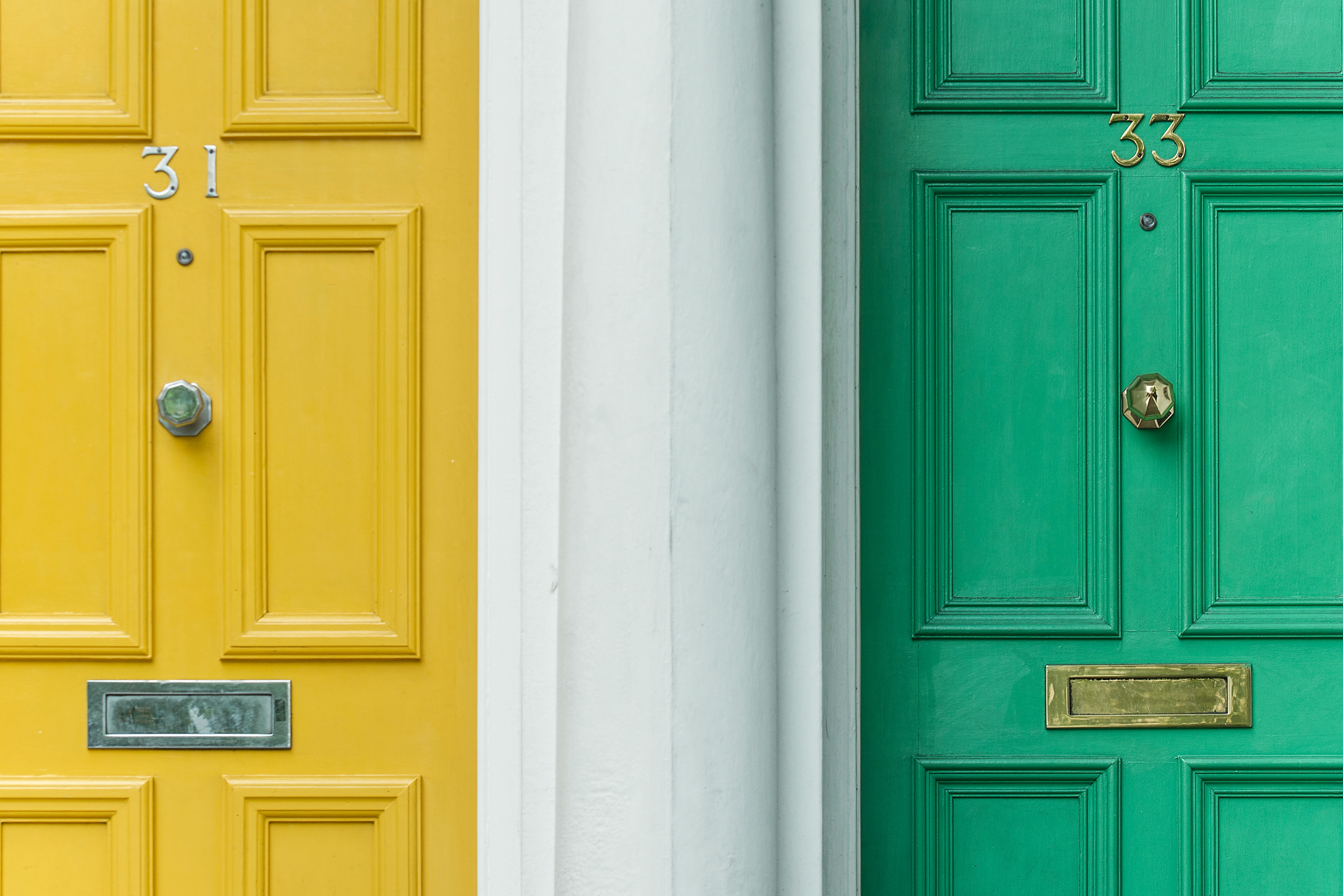 Brightly painted yellow and green doors with house numbers 31 and 33.