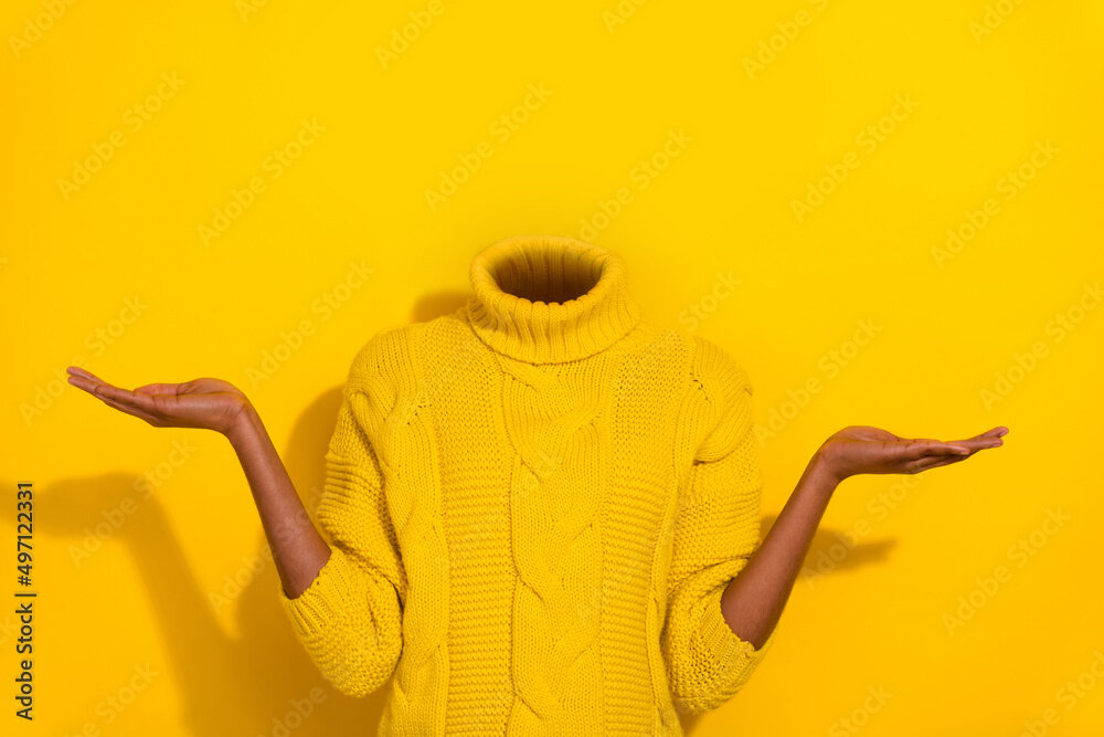 Headless person in yellow sweater gesturing with hands on a yellow background.