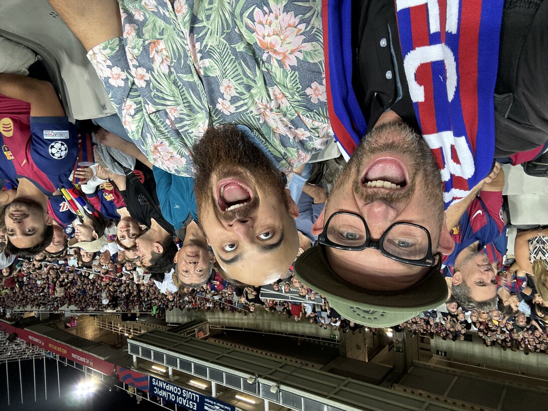 Excited fans cheering during a soccer match at a packed stadium.
