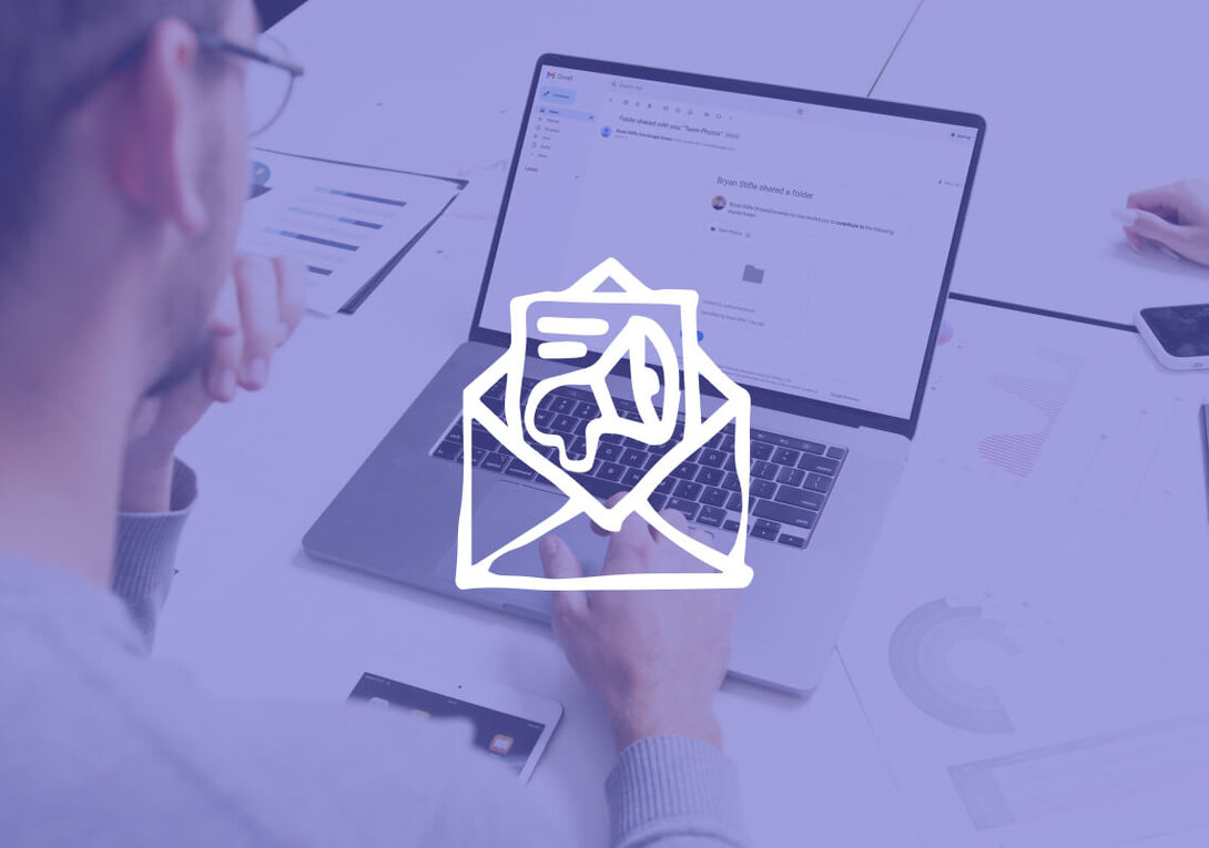 Person working on email marketing on a laptop with charts on desk.