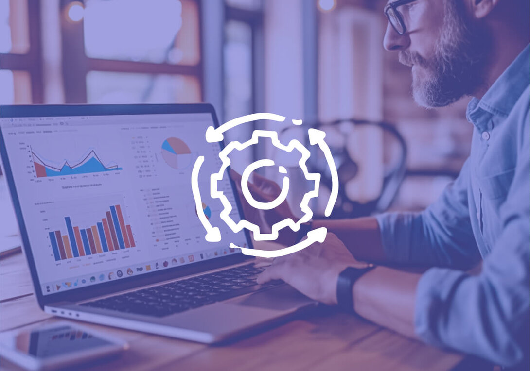 Man analyzing charts on laptop with gear icon overlay.