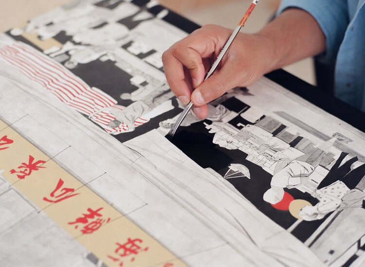 Hand painting intricate Asian art on canvas with red calligraphy.