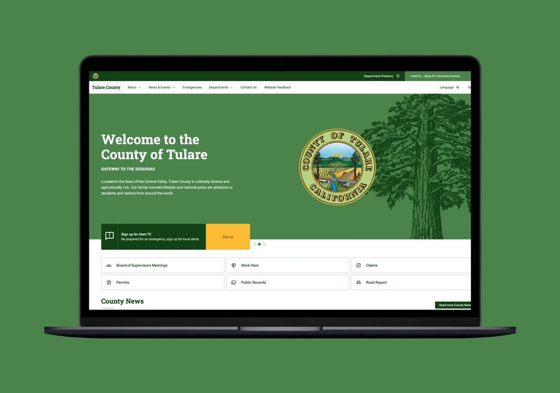 Tulare County website homepage on a laptop screen with green background.