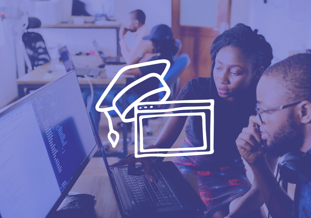 Two people collaborating on a laptop, programming code visible on the screen.