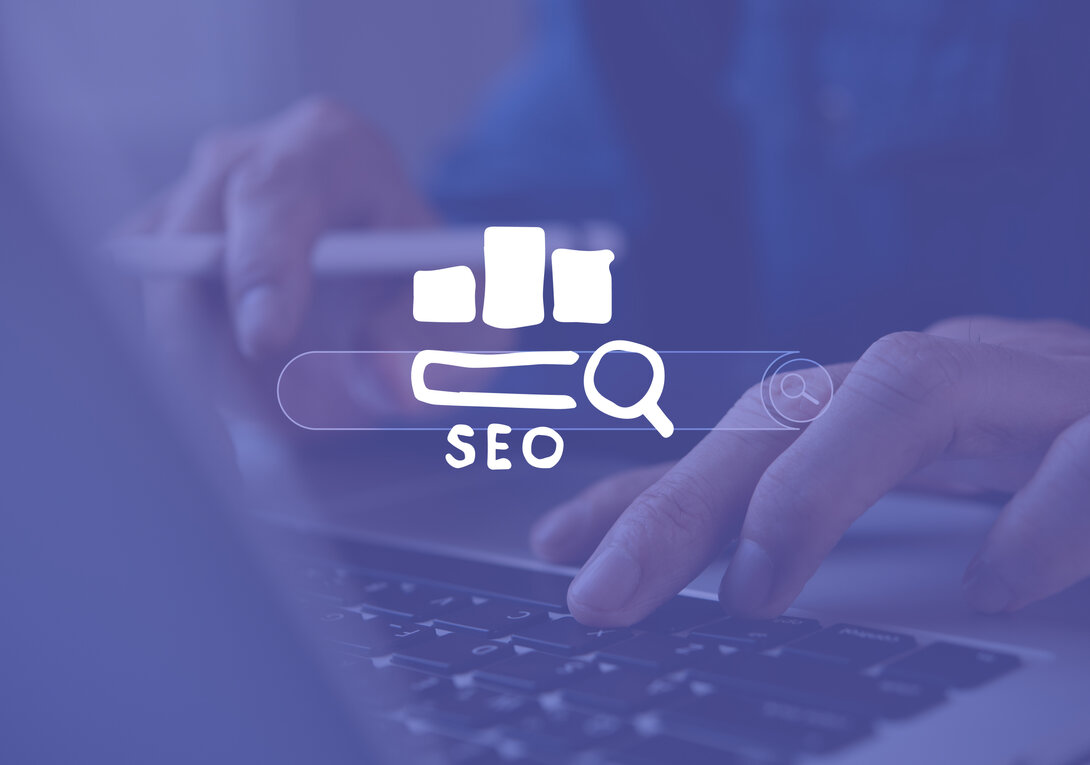 Hands typing on laptop keyboard with SEO graphic overlay.
