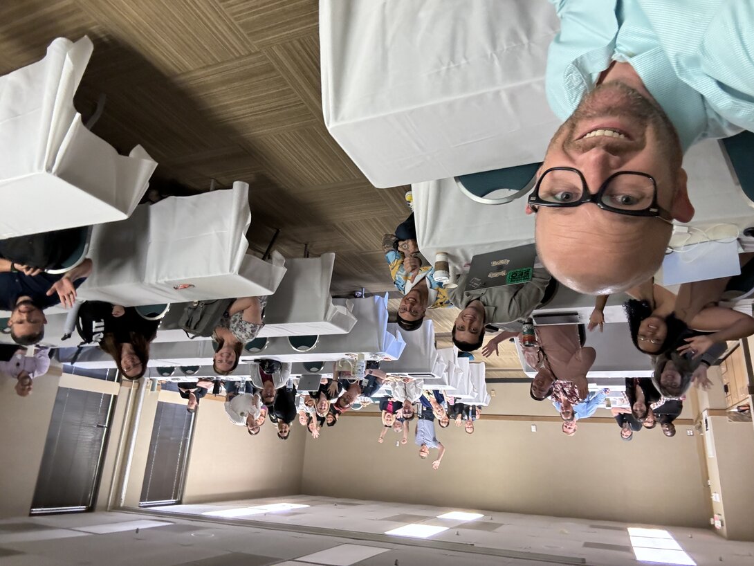 Group attending a conference in a classroom setting with laptops.