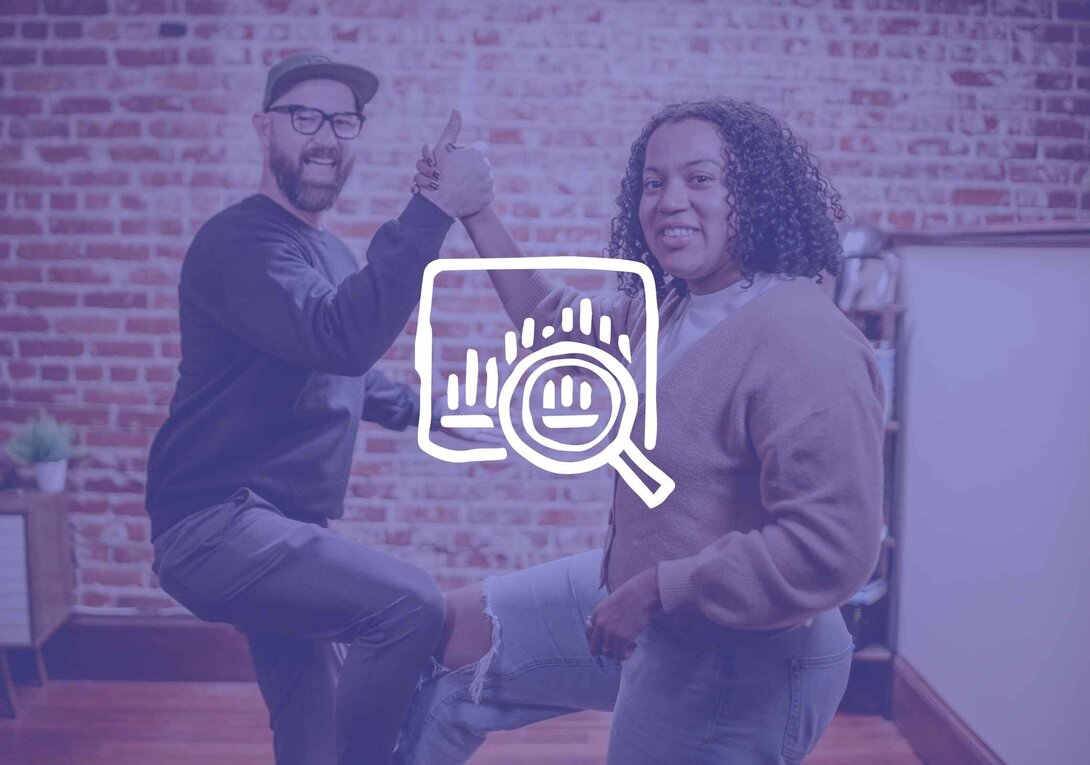 Two people giving a thumbs-up by a brick wall, overlay of a magnifying glass and graph.