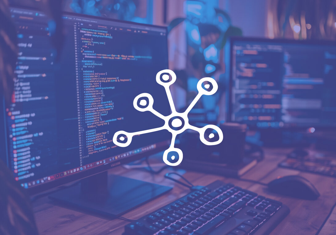 Computer monitors display coding with a network symbol overlay.